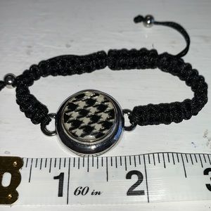 Adjustable braided black cord bracelet with one interchangeable snaps.NWOT